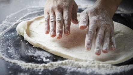 Ilustración de la técnica del dedo para estirar la masa de pizza, empujando el aire del centro hacia afuera