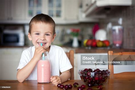 Niño feliz bebiendo un batido de frutas casero