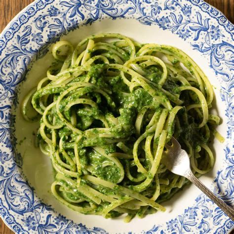 fotografía de un plato de tallarines con salsa verde brillante y cremosa