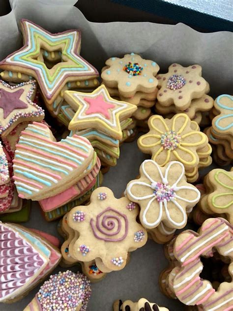 Mesa con una variedad de galletas decoradas con glaseado y diferentes formas