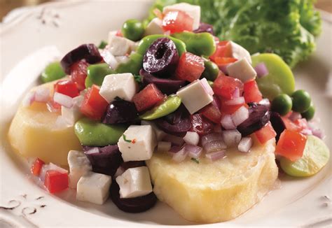 Plato de solterito arequipeño servido sobre un lecho de lechuga con colores vibrantes de vegetales y queso