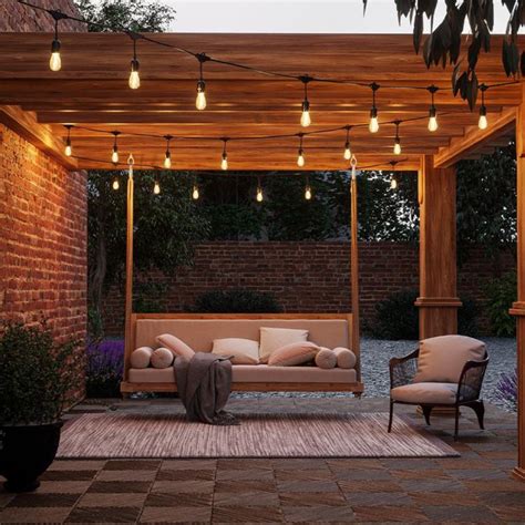 Terraza con barbacoa iluminada con guirnaldas de luces y mobiliario acogedor
