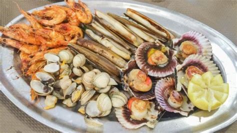 Plato generoso de mariscada variada con langostinos, mejillones, calamares y trozos de pescado en una salsa cremosa.