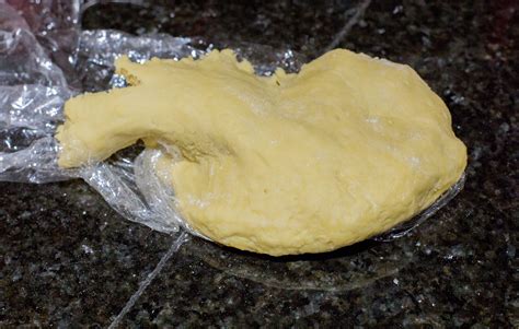 Masa de fideos caseros siendo amasada y estirada sobre una mesada enharinada