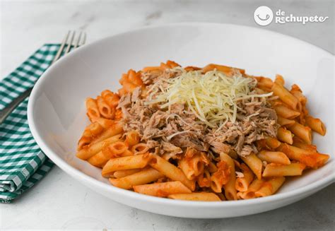 Plato de pasta Penne con atún y salsa de tomate, decorado con albahaca fresca.