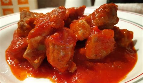 Plato de carne de cerdo en salsa de tomate con guarnición