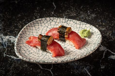 Plato de niguiris variados, con atún, salmón y anguila, presentados artísticamente