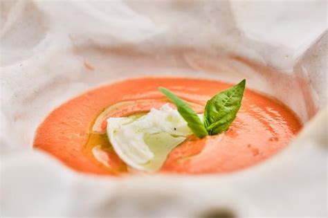 Fotografía gastronómica de un bol con mayonesa de tomate decorada con hierbas aromáticas y tomates secos