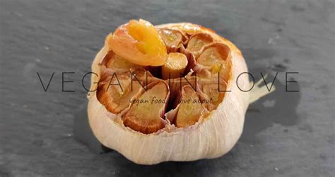 Cabezas de ajo enteras preparadas para asar, con la parte superior cortada y rociadas con aceite de oliva