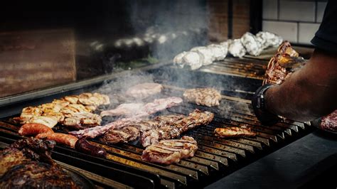 Fotografía de una parrilla argentina tradicional con cortes de carne de alta calidad y brasas encendidas