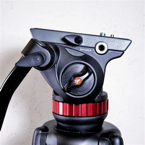 Fotografía de un kit de trípode Manfrotto 502A con cámara DSLR montada, mostrando la fluidez de movimiento.