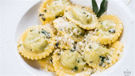 Plato de ravioles caseros de espinaca recién preparados con salsa cremosa y queso parmesano