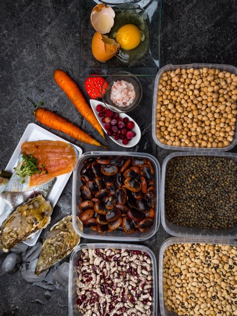 Fotografía de un surtido de alimentos saludables para la vista: zanahorias, espinacas, arándanos, pimientos, nueces y cebollas