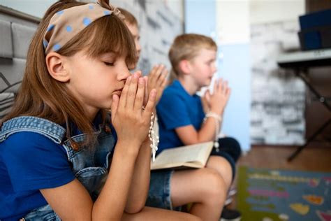 maestra orando con niños