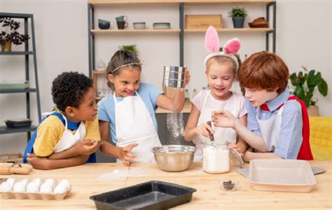 Niños cocinando con alegría en una cocina colorida