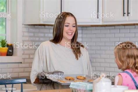 Adolescente sonriendo mientras hornea galletas