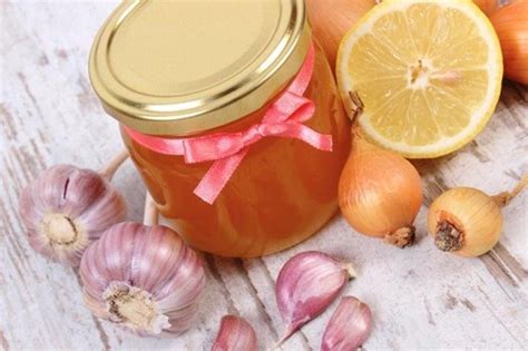 Ingredientes frescos de cebolla, ajo y miel en un frasco de vidrio para preparar jarabe casero