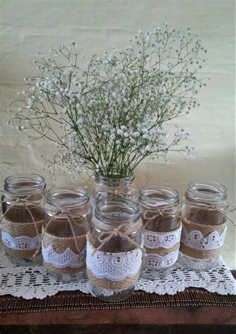 Variedad de frascos de vidrio de diferentes tamaños usados como centros de mesa con elementos decorativos