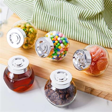 Frascos de vidrio pequeños llenos de mermelada o mezclas de galletas como recuerdos de fiesta