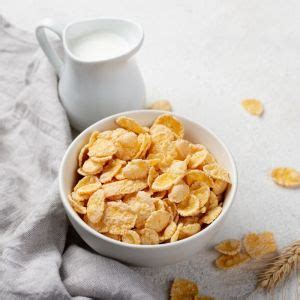 Tazón de cereales de maíz sin azúcar con leche, frutos rojos y rodajas de plátano