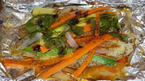 Esquema que muestra cómo colocar el filete, los vegetales y los condimentos sobre el papel aluminio o la hoja de plátano antes de cerrarlo.