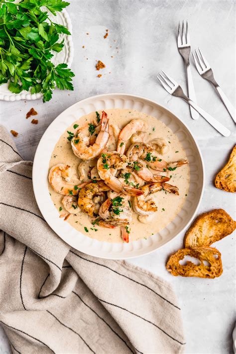 Plato de camarones a la crema con ajo, servidos con pan tostado y perejil fresco