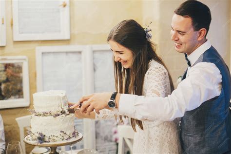 Foto de una pareja emocionada cortando un pastel que revela un color, con invitados observando.