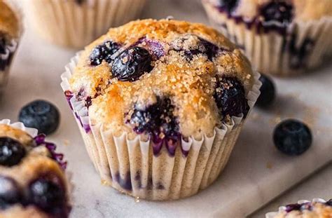 Foto de primer plano de muffins de arándanos recién horneados con una textura esponjosa y arándanos frescos a la vista