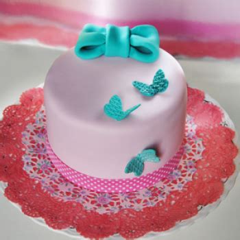 Primer plano de un pastel cubierto con fondant con detalles decorativos