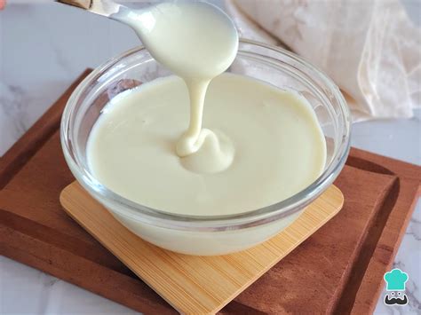 Foto paso a paso de cómo mezclar la leche condensada y el jugo de limón, luego incorporar la crema montada con movimientos envolventes.