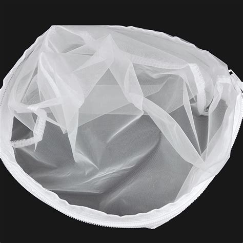 Ricota casera recién preparada en una bolsa de tela coladora sobre un bowl