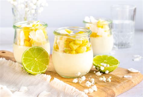 Fotografía de panna cotta de piña colada servida en vasito con puré de fresas