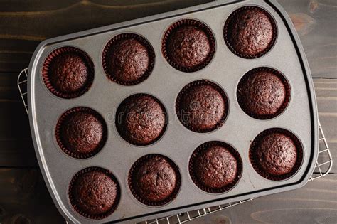 Fotografía profesional de cupcakes de chocolate recién horneados con un copete alto y textura esponjosa