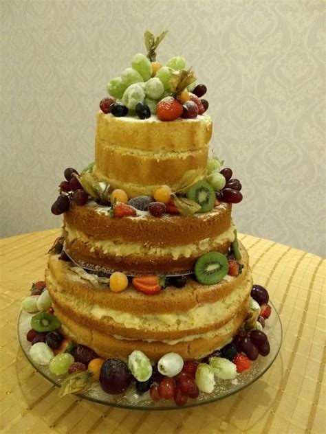 Foto de un Naked Cake decorado con frutas y flores frescas