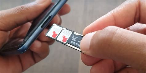 Persona quitando la funda protectora y la tarjeta SIM de un teléfono mojado