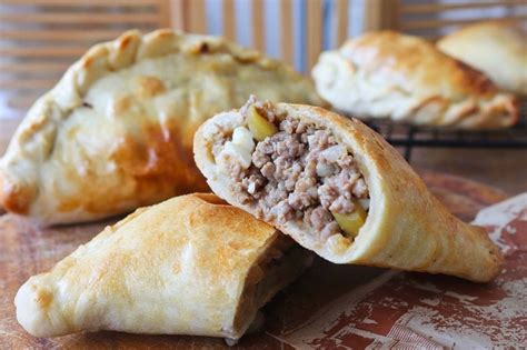 Variedad de empanadas con diferentes rellenos cortadas por la mitad