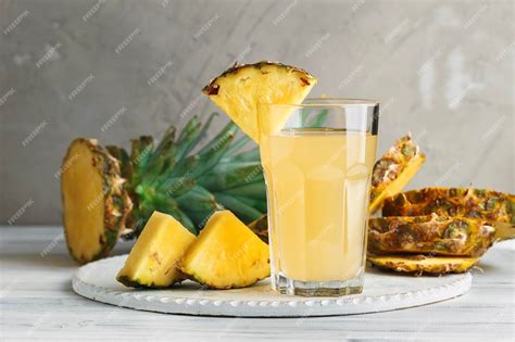 Vaso de jugo fresco de piña y sábila, con los ingredientes al lado