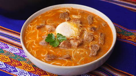 Plato con ingredientes frescos para Sopa Criolla: ají panca, cebolla, ajo, carne molida, fideos y leche evaporada.