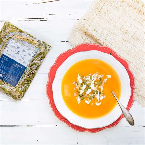 Sopa cremosa de zapallo, jengibre y leche de coco decorada