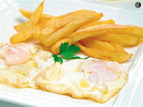 Plato de patatas a lo pobre con huevos fritos