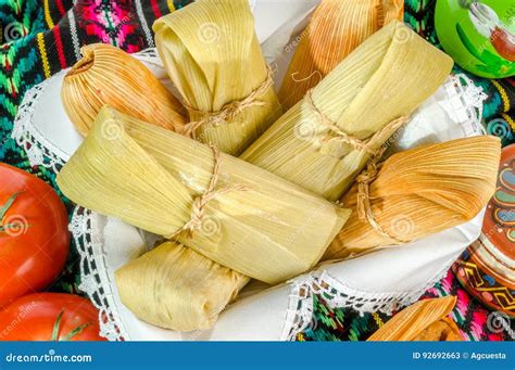 Foto de tamales mexicanos recién hechos y envueltos en hojas de maíz.