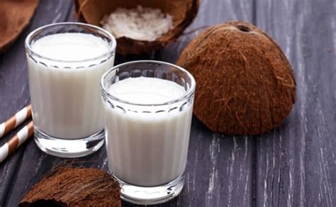 Imagen de cocos frescos y rallado, junto a un vaso de leche de coco casera