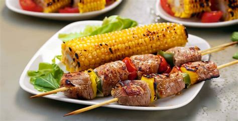 Imagen de brochetas de corazón de res cocinándose a la parrilla sobre brasas de carbón