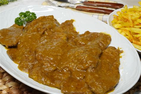 plato terminado de filetes de ternera en salsa con guarnición