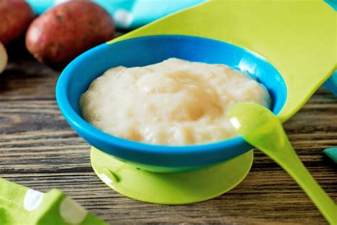 Ilustración de un bebé sonriente comiendo un puré de arroz con pollo y verduras.