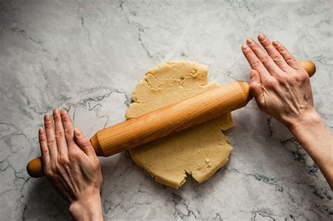Masa de galletas extendida sobre una superficie enharinada con un rodillo