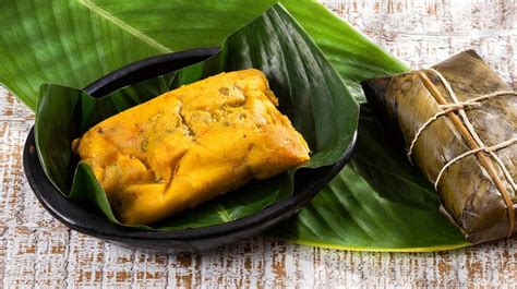 Tamal colombiano abierto en hoja de plátano mostrando el relleno