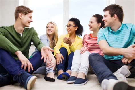 Grupo de jóvenes adolescentes riendo y conversando en un ambiente amigable