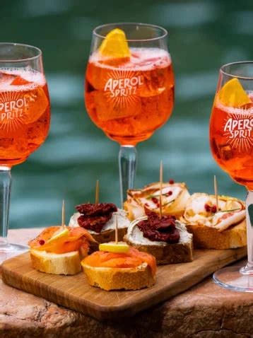 foto de Aperol Spritz con un típico picoteo italiano (bruschetta, aceitunas, embutidos)