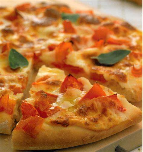 Imagen de galletas cracker decoradas con tomate, queso y orégano simulando una pizza pequeña